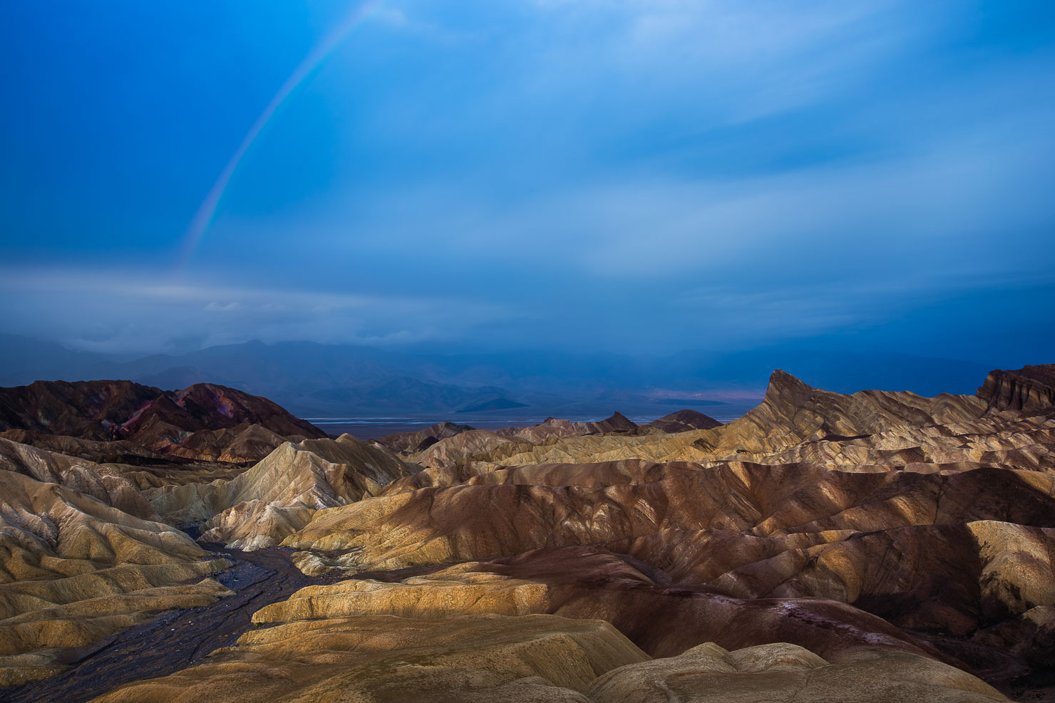 Zabriskie Point badlands at sunrise with golden light, Death Valley National Park